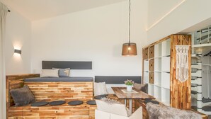 Moderni huone, jossa on puinen penkki, ruokapöytä ja portaikko.
