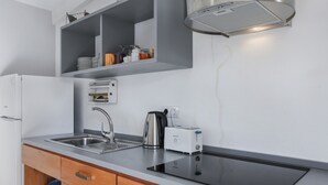 Een moderne keuken met een ingebouwde kookplaat, een spoelbak en een broodrooster.