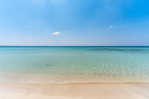 A beach with clear water and a sandy shore. - Apartment near the sea - Appartamento Torre Lapillo (torre lapillo)