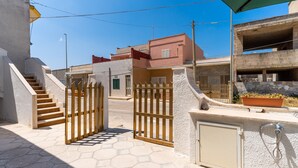A gated entrance with a staircase, a potted plant, and a water feature. - Apartment near the sea - Appartamento Torre Lapillo (torre lapillo)