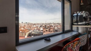 A kitchen with a large window overlooking a cityscape. - Hostal Juliette & Coworking (Madrid)