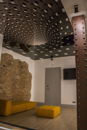 A modern interior with a unique ceiling design, a brick wall, and a door labeled "201". - Hostal Juliette & Coworking (Madrid)