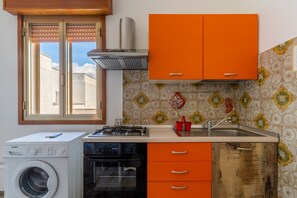 Une cuisine compacte équipée d’un lave-linge, d’un lave-vaisselle et d’une cuisinière.