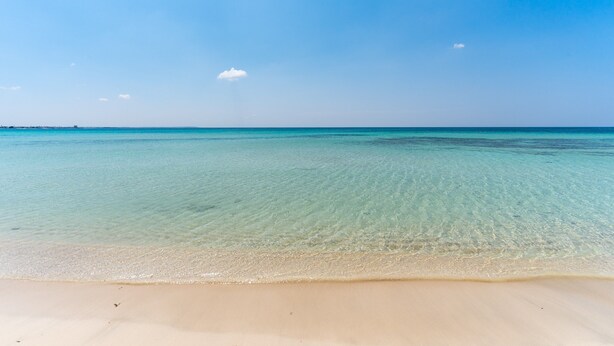 A beach with clear water and a sandy shore. - Close to the beach with courtyard - Apartment Lapillo (torre lapillo)