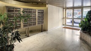 A modern lobby with a marble floor, a metal bulletin board, and potted plants. - N&J - BERLIOZ SUITE - Central - Close sea (Niza)