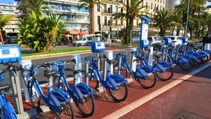 A row of blue bicycles parked in a designated area with a red bike lane. - N&J - BERLIOZ SUITE - Central - Close sea (Niza)