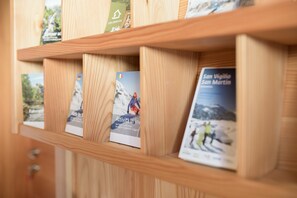 A wooden shelf with travel brochures.