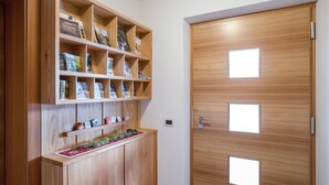 A wooden door with three square windows and a built-in wooden shelf with books and decorative items. - Idyllic Apartment "Kronplatz" with Balcony, Garden and Wi-Fi (San Martino in Badia)