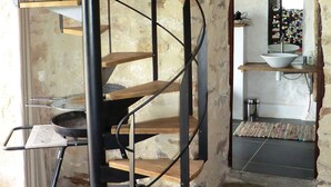 Une cuisine dotée d’un escalier en colimaçon, d’un évier et d’un porte-ustensiles suspendu.