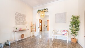Un hall spacieux doté d’un sol en marbre, d’un banc blanc, d’une plante en pot et d’un élément décoratif mural.
