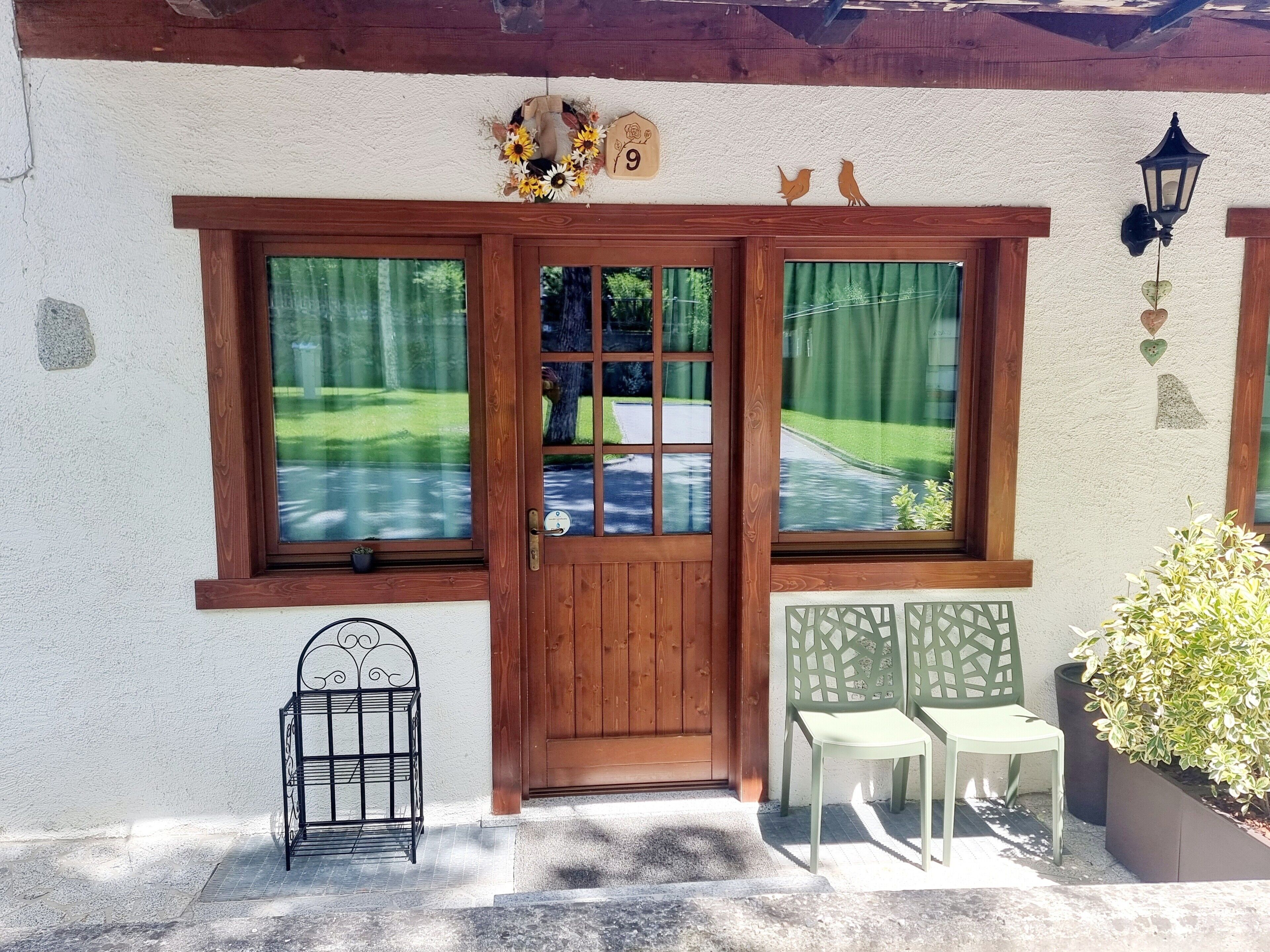 A wooden door with a window, a small birdhouse, and a bird sculpture on the wall.