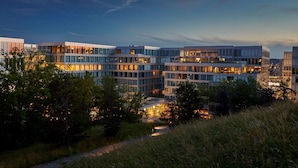 Un bâtiment moderne à étages, doté de grandes fenêtres et d’une façade bien éclairée.