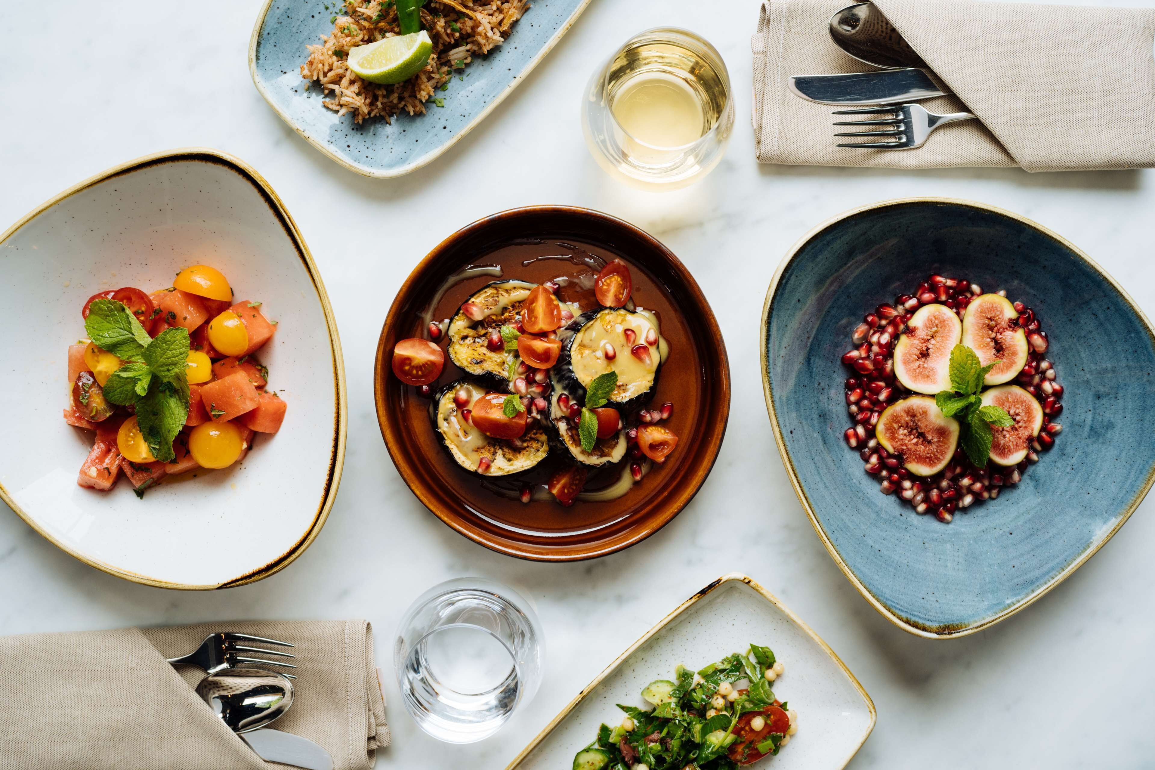 A table with various dishes, utensils, and glasses.