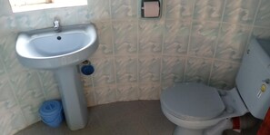 Bathroom features a light blue sink and white toilet, set against a backdrop of patterned tiles.