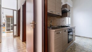 Une cuisine avec des meubles de rangement en bois, une cuisinière et un four.