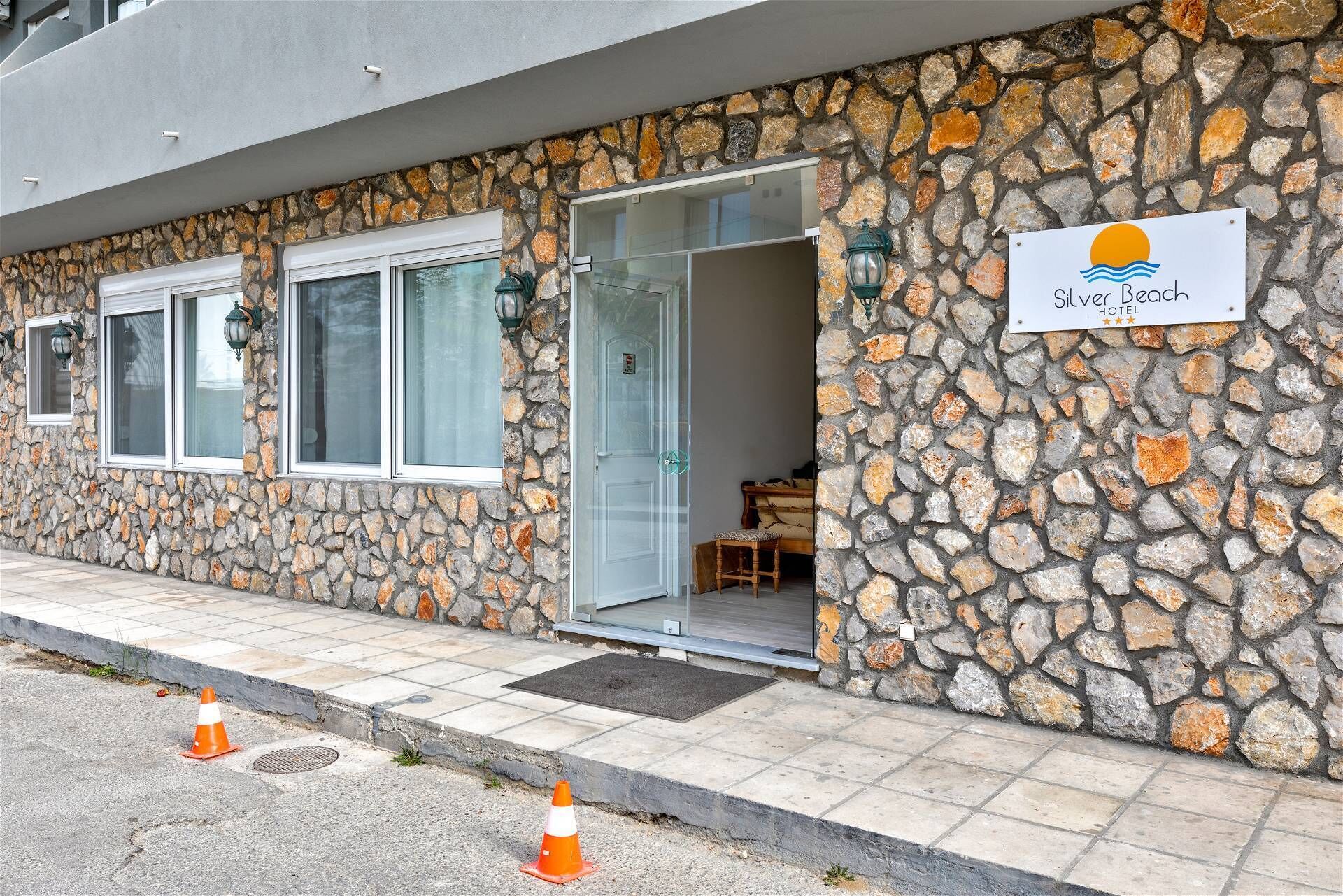 A stone building with a sign for Silver Beach Hotel.