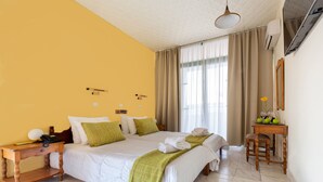 A hotel room with a bed, bedside table, and a small wooden chair. - Silver Beach Hotel (Kos)