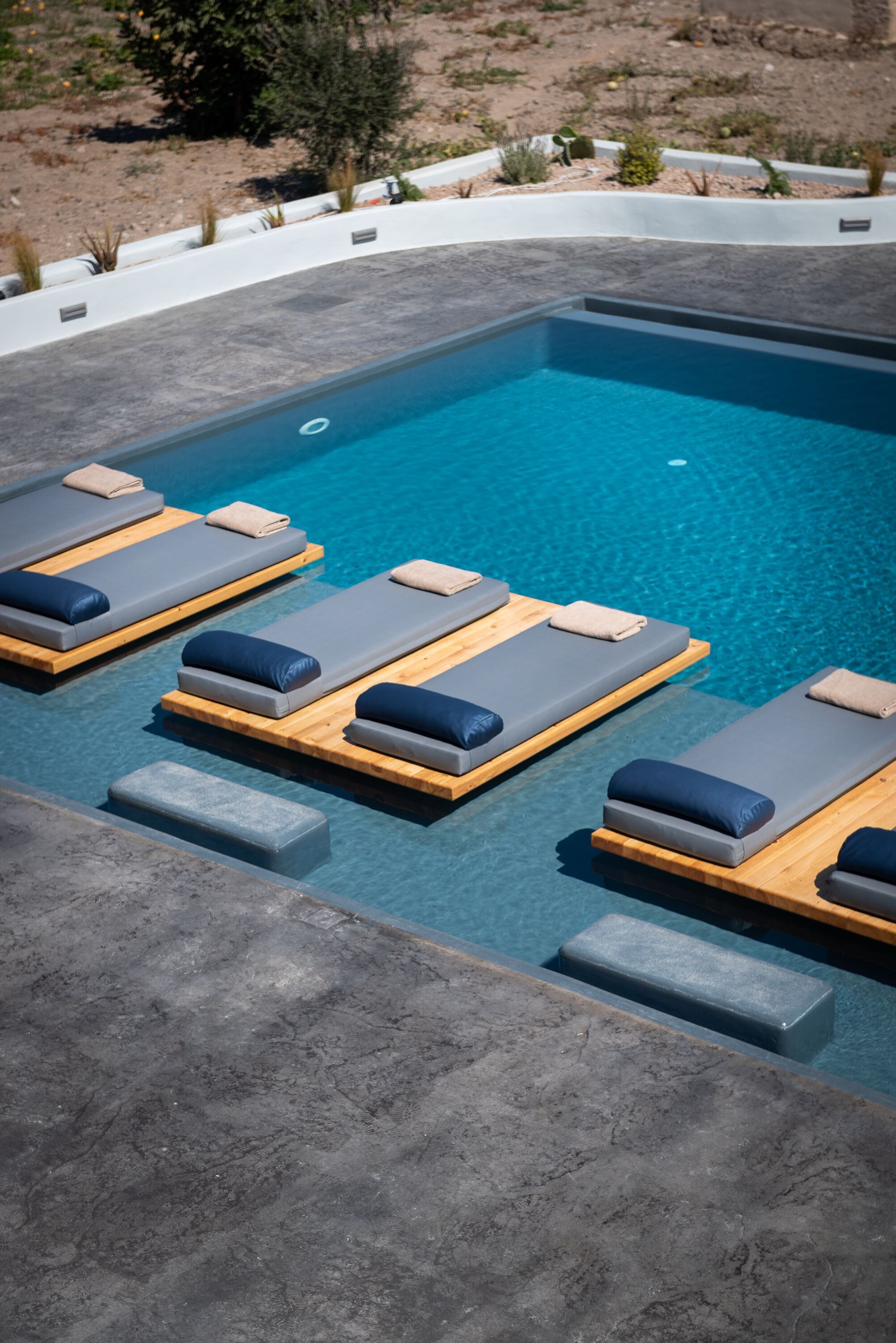 Area piscina con lettini e un pontile in legno.