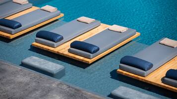Area piscina con lettini e un pontile in legno.