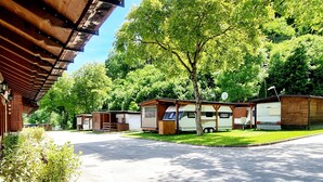 Un parque para caravanas con varias caravanas, un camino pavimentado y un edificio de fachada de madera.