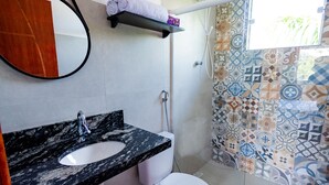 A bathroom with a marble sink, toilet, and shower. - Apartment furnished with air Penedo RJ (Jardim das Rosas)