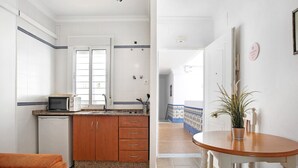 A compact kitchen with a microwave, refrigerator, and wooden cabinets.