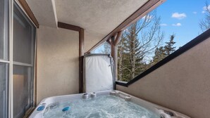 A hot tub with a view of trees and a window.