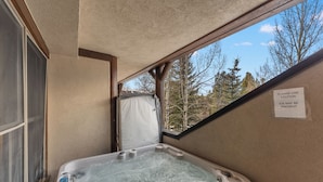 A hot tub with a view of trees through a window.