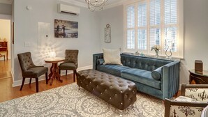 A living room with a blue sofa, two armchairs, a round coffee table, and a patterned rug. - Heated Pool Access | 5*Clean | Flex Cancelation (Savannah)