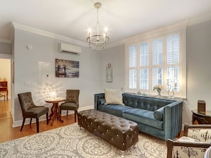 A living room with a blue sofa, two armchairs, a round coffee table, and a patterned rug. - Heated Pool Access | 5*Clean | Flex Cancelation (Savannah)