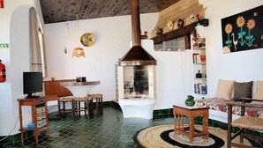 Een rustieke keuken met een schoorsteen, houten meubels en een vloer van groene tegels.