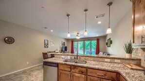 A kitchen with granite countertops, wooden cabinets, a dishwasher, and pendant lights. - RG 111 Guadalupe Fortress of Awesome (New Braunfels)