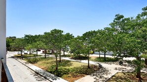 Ein Park mit Bäumen, einer Bank und einem Weg.