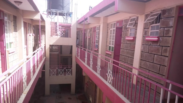 Un atrium à plusieurs niveaux, doté de rampes roses et d’un escalier central.