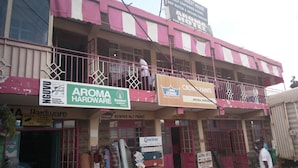 Un immeuble à plusieurs étages, sur lequel on peut voir des enseignes indiquant «Aroma Hotel» et «Crown Paints».