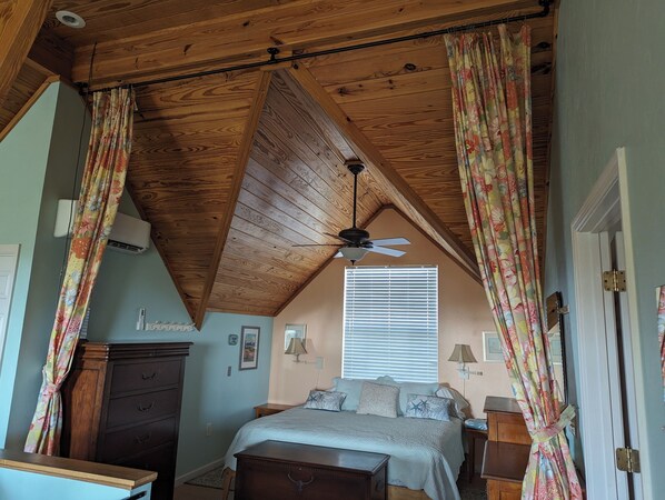 A bedroom with a sloped ceiling, a ceiling fan, a bed with multiple pillows, a dresser, and a window with blinds. - The Sandy Seagull Hideaway, pristine Cayo Costa Island, SW Florida! (Cayo Costa)