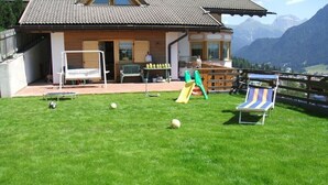Una casa con patio, scivolo e vista sulle montagne.