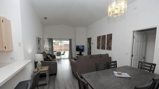 A modern living room with a dining area, a sofa set, and a TV. - Dream in Clermont (Clermont)