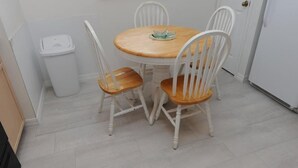 A small dining area with a round wooden table and four white chairs. - Dream in Clermont (Clermont)