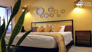 A bedroom with a bed, pillows, a bedside table, and wall decorations. - Gorgeous Suite w/Premium Ammenties in Downtown (Valladolid)