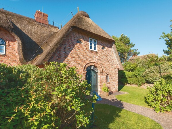 A traditional brick house with a thatched roof, a green door, and a brick chimney. - Biike Hüs from A&M - Biike Hüs (Kampen (Sylt))