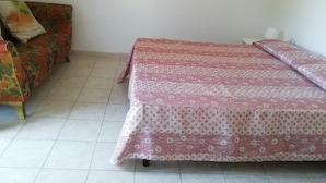Een kamer met een bed en een slaapbank.