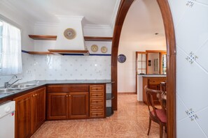 A kitchen with wooden cabinets, a built-in oven, and a tiled backsplash.