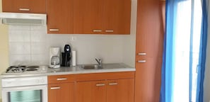 Habitación clásica | Cocina privada | Frigorífico, horno, placa de cocina y cafetera o tetera