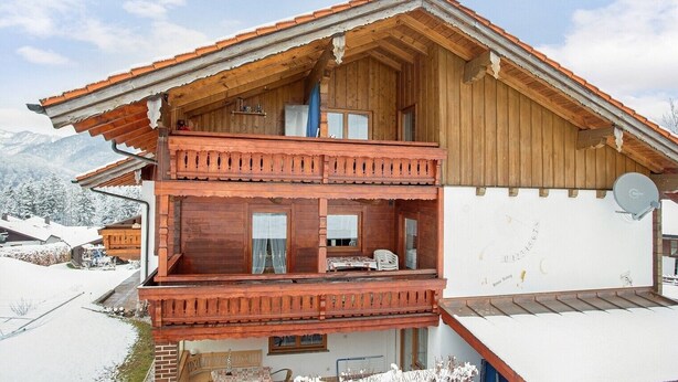 A wooden chalet with a balcony, a satellite dish, and a snowy landscape. - Apartment "König" with Terrace, Wi-Fi, Garden & Mountain View (Berchtesgaden)