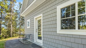 A house with a grey siding exterior, a front door, and a window. - The Overlook at Orchard Hills -- Hilltop Retreat,  Near Acadia (Tremont)