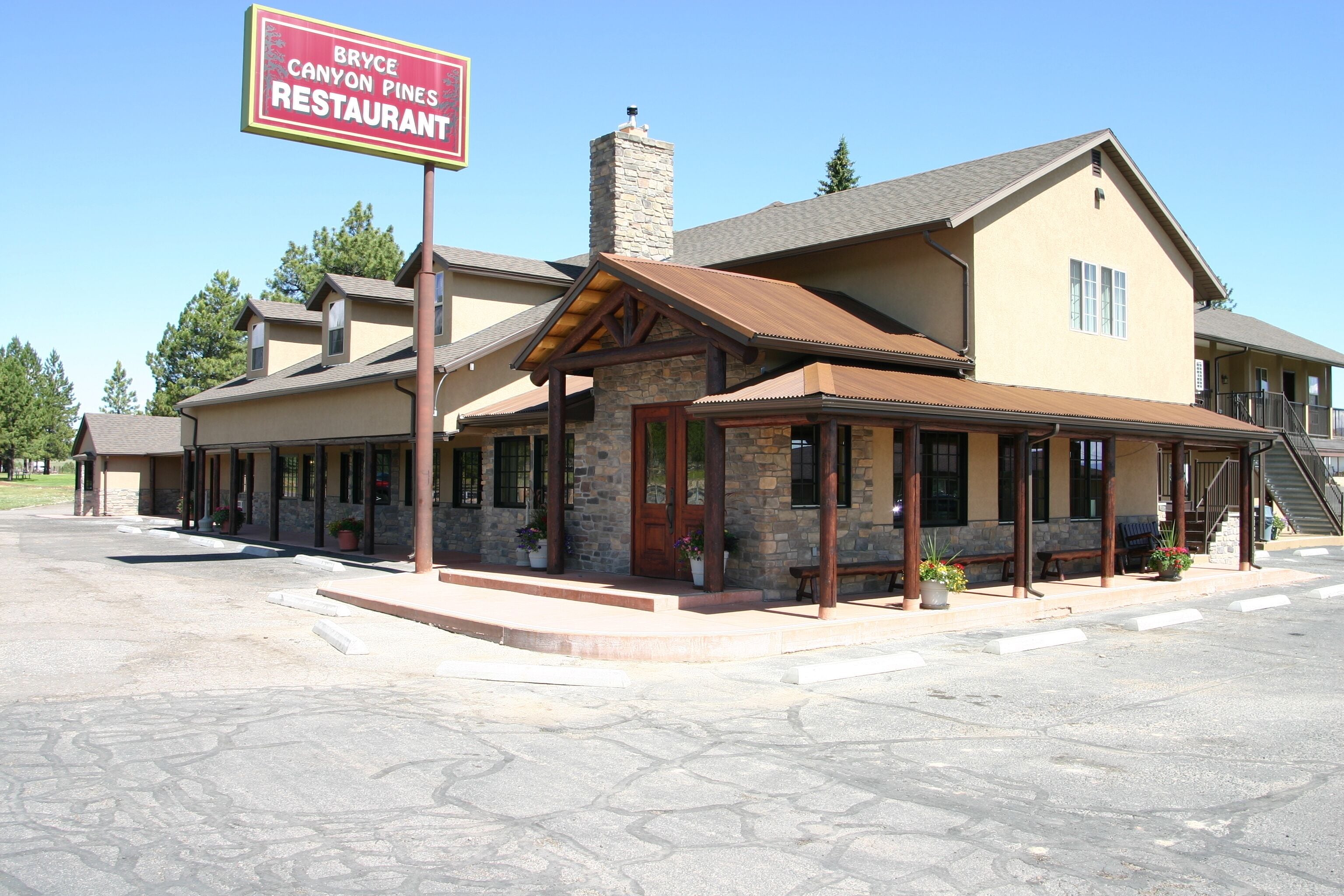 A restaurant with a stone facade, wooden beams, and outdoor seating.