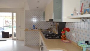 Cucina con piano cottura a gas, lavello e finestra.