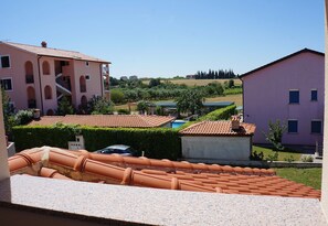 A residential area with terracotta-tiled roofs, a swimming pool, and a clear blue sky. - Willa Trojka (Novigrad)