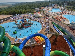 Un parque acuático con múltiples piscinas, toboganes y una zona de juegos amplia.